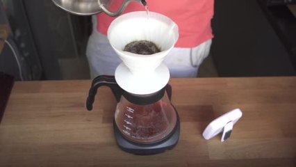 慢慢地將熱開水涌入焙炒咖啡的咖啡師